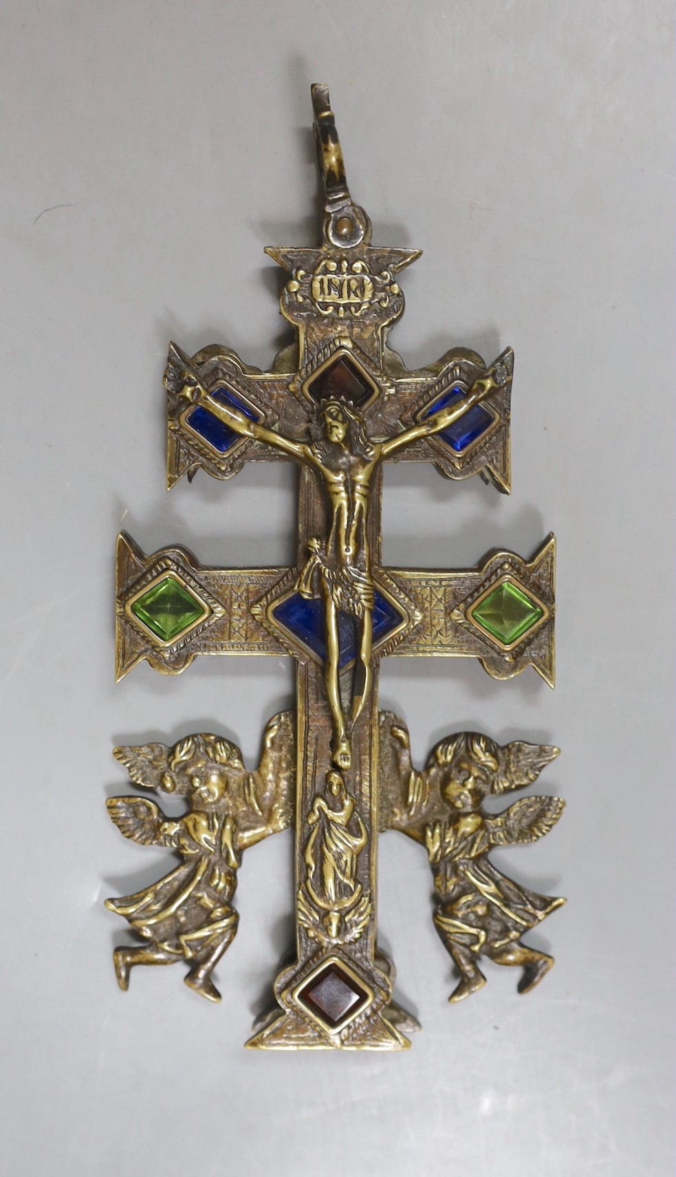 A brass stained glass crucifix inscribed ‘INRI’ with swivel movement - 18cm high